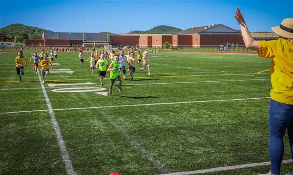 Students race down the football field